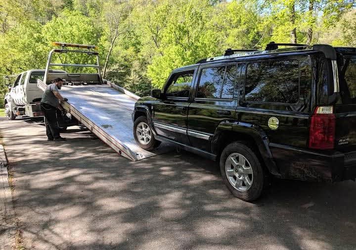 Vehicle positioned beside an Express Towing and Recovery flatbed